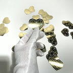 Gold mirror die-cut sticker catching the light in a gloved hand