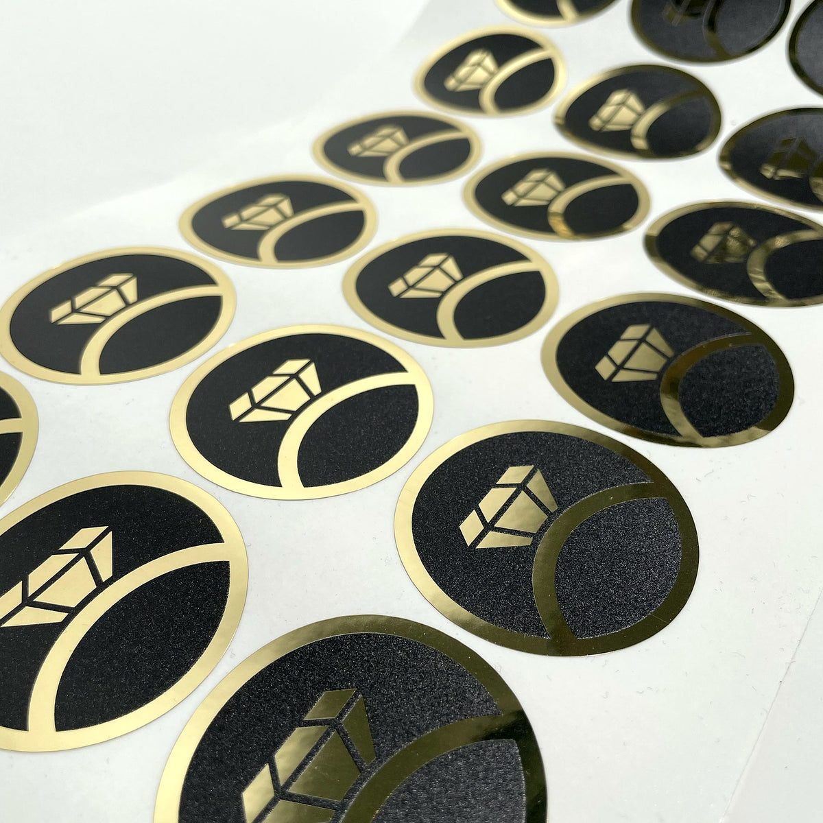 Round labels with gold print on a black background