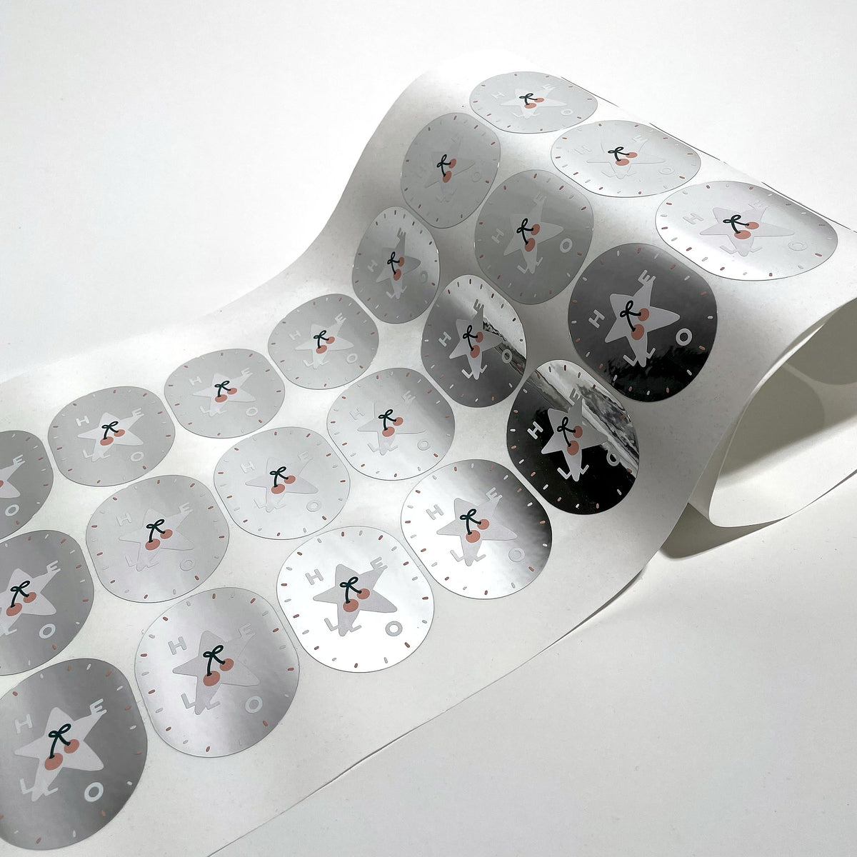 Metallic silver round labels curling off the roll